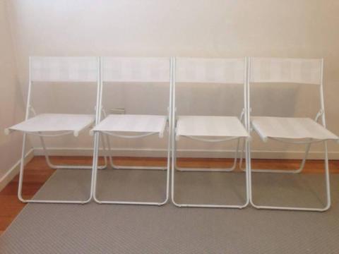 Four White Folding Chairs
