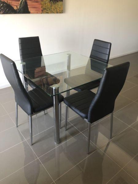 Glass top dinning table and four chairs