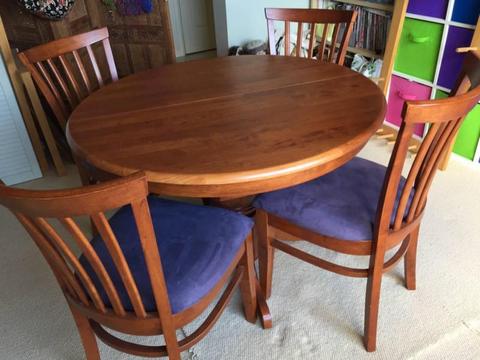Round extendable dining table with four chairs