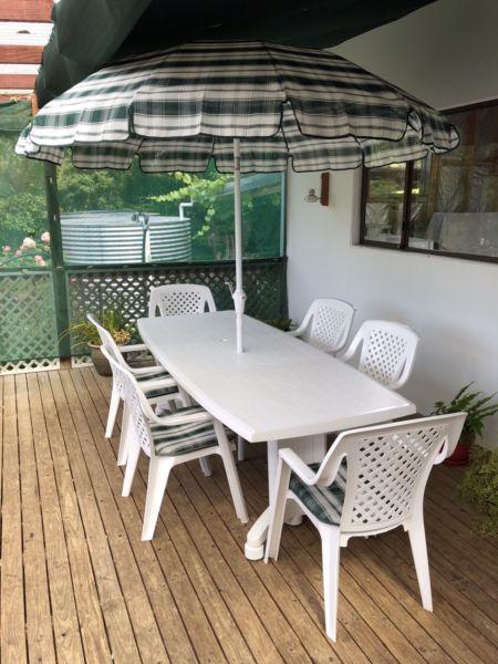 Outdoor extendable dining setting with matching cushions and umbrella