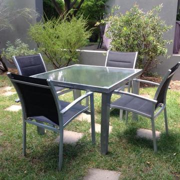 Outdoor garden setting, glass topped table and four chairs