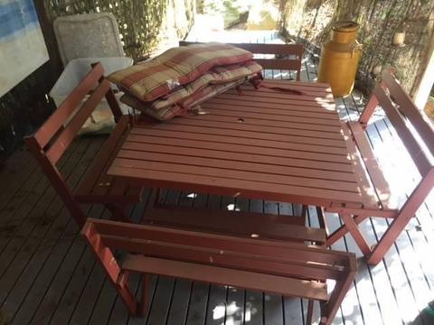 Used wooden patio table with four benches and cushions