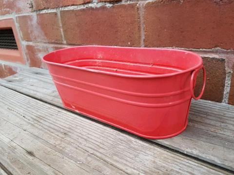Small metal plant pot with holes for drainage