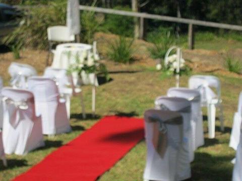 DIY Wedding. Red carpet, white satin chair covers, various sashes