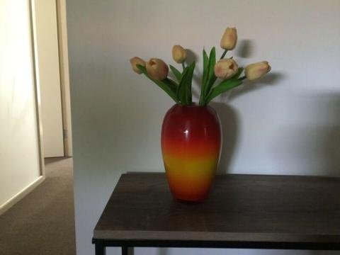 Bright coloured vase with artificial tulips