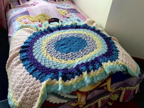 Rainbow-coloured knitted rug