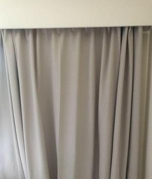 Beige floor length pleated curtains with adjustable railing