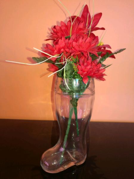 Glass boot vase with red flowers