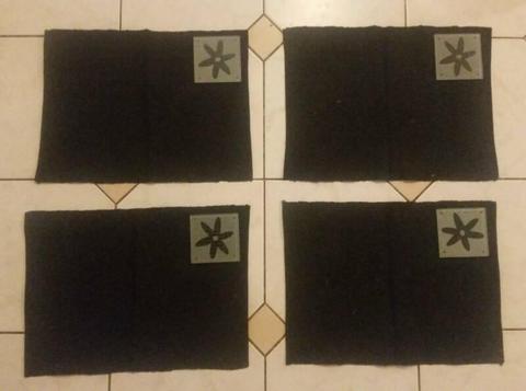 4 black fabric placemats and 4 glass coasters