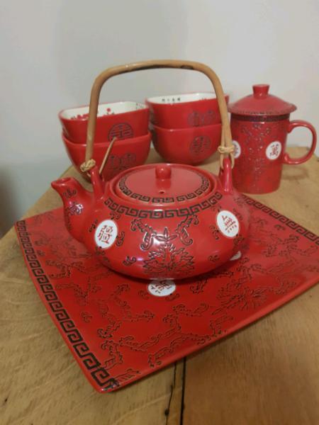 Asian teapot with matching cup, serving plate and bowls