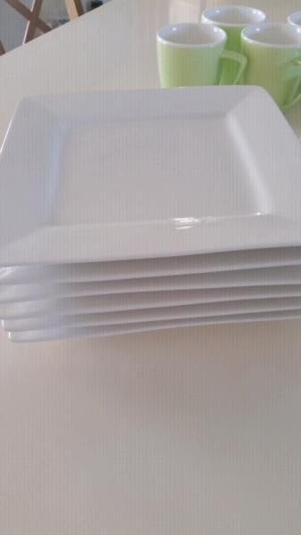 Six white side plates