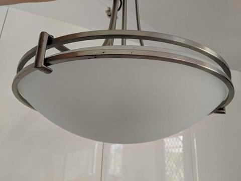 Two hanging light fixtures; stainless steel and frosted glass