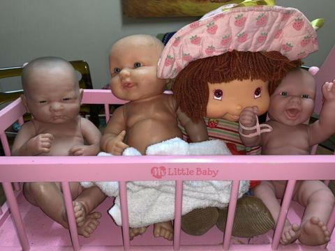 Berenguer dolls, strawberry shortcake and rocking cradle